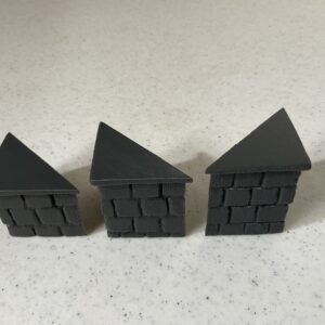 Three black puzzle pieces shaped like houses with brick patterns.