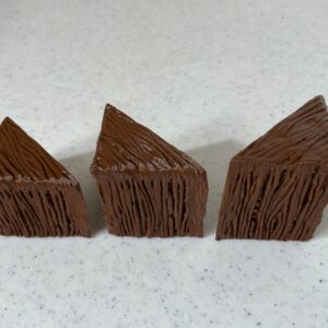 Three pieces of chocolate cake with textured frosting on a white surface.