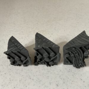 Three black rubber stamps with intricate patterns on a white surface.