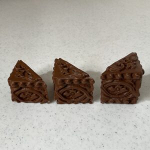 Three intricately carved wooden blocks with floral patterns.