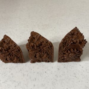 Three triangular pieces of chocolate fudge arranged on a white surface.